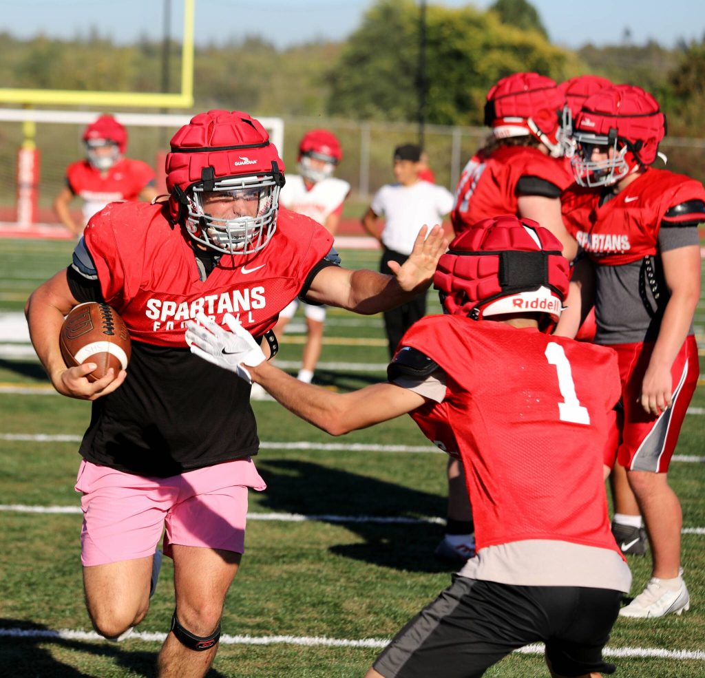 Senior linebacker and running back Cruise Swanson stiff arms a teammate during a drill at the Stanwood High School football practice at Bob Larson Stadium in Stanwood, Washington on Aug. 30, 2024. (Taras McCurdie / The Herald)