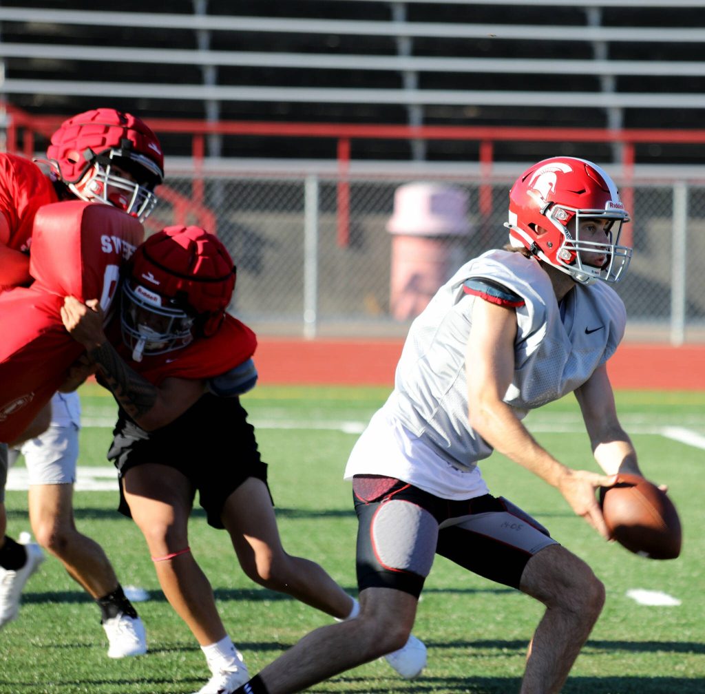 Senior quarterback Luke Brennan pitches the football during a Stanwood High School football practice at Bob Larson Stadium in Stanwood, Washington on Aug. 30, 2024. (Taras McCurdie / The Herald)