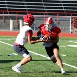 Sophomore quarterback Alex Maldonado (left) hands off the football to senior safety and running back Canyon Bumgarner during the Stanwood High School football practice at Bob Larson Stadium in Stanwood, Washington on Aug. 30, 2024. (Taras McCurdie / The Herald)