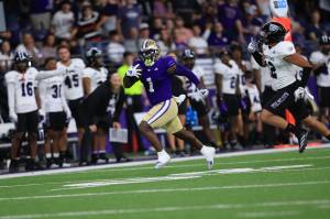 Washington Huskies running back Jonah Coleman runs away from the Weber State defense at Husky Stadium on August 31,2024. (Photography Courtesy of Scott Eklund / Red Box Pictures / Washington Athletics)