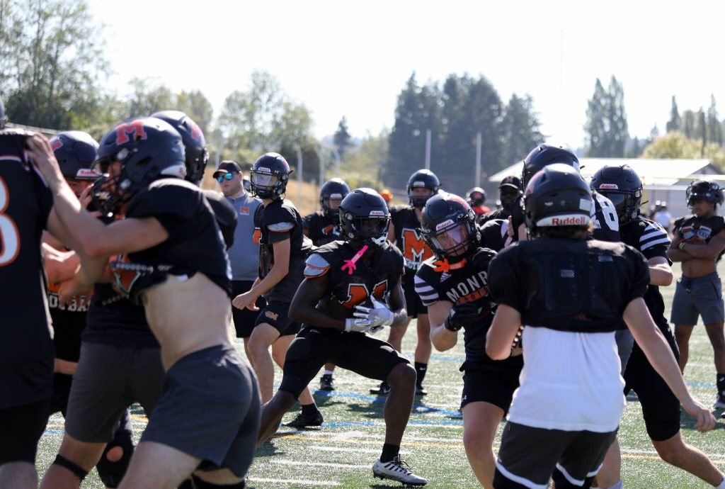 Senior running back and linebacker Carl Watson III runs with the football during a drill at the Monroe High School football practice. (Taras McCurdie / The Herald)