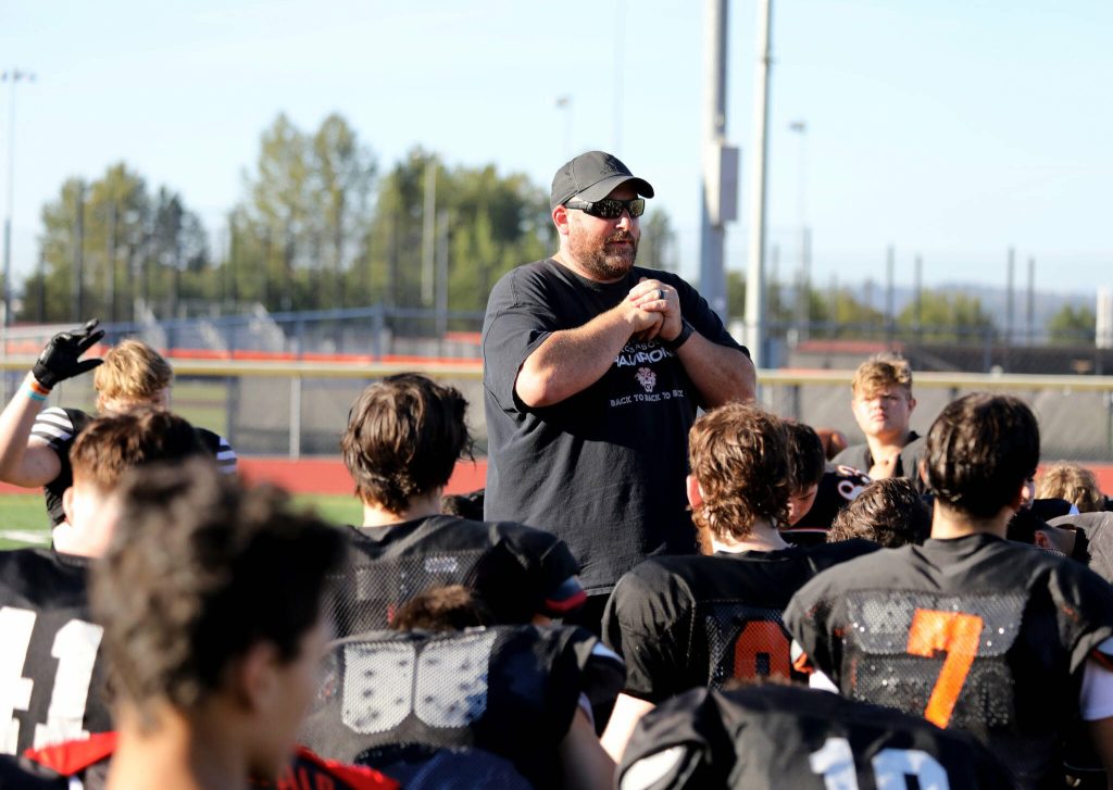 Scott Darrow, whos entering his fifth year as the Monroe High School head football coach, talks with his team at the end of practice in Monroe on Aug. 29. (Taras McCurdie / The Herald)