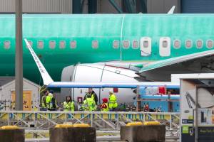 Workers next to an unpainted 737 aircraft and unattached wing with the Ryanair logo as Boeing's 737 factory teams hold the first day of a "Quality Stand Down" for the 737 program at Boeing's factory in Renton on Jan. 25. (Jason Redmond/AFP/Getty Images)