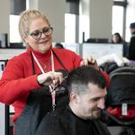 Bethany Teed, a certified peer counselor with Sunrise Services and experienced hairstylist, cuts the hair of Eli LeFevre during a resource fair at the Carnegie Resource Center on Wednesday, March 6, 2024, in downtown Everett, Washington. (Ryan Berry / The Herald)