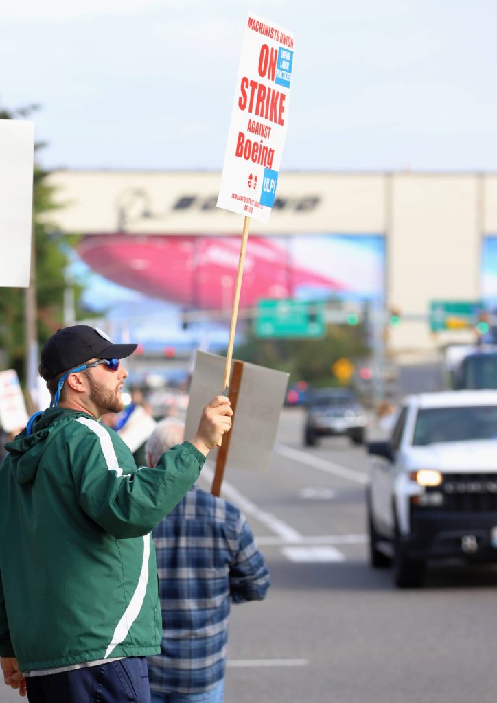 A Boeing employee holds a sign along Airport Road during a picket from Machinists union members at the Everett Boeing plant on Friday, Sept. 13, 2024, in Everett, Washington. (Michael Henneke / The Herald)
