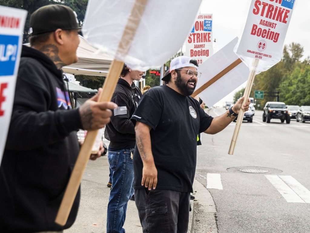Matt Saldivar, a lead mechanic at Boeing for 5 years, smiles while picketing with other Boeing workers on strike on Monday, Sept. 16, 2024, in Everett, Washington. (Olivia Vanni / The Herald)