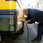 Snohomish School Districts Clayton Lovell plugs in the districts electric bus after morning routes on March 6, at the district bus depot in Snohomish. Repeal of the Climate Commitment Act by passage of I-2117 would jeopardize climate efforts, such as providing electric school buses. (Ryan Berry / The Herald file photo)