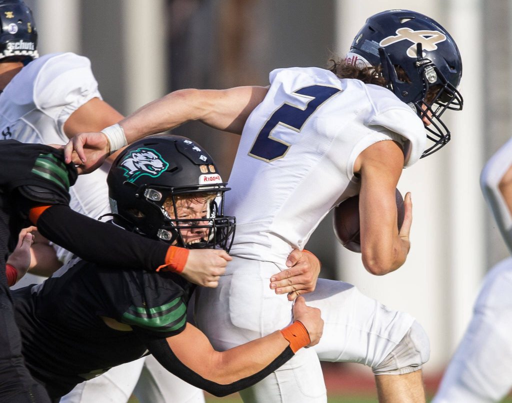 Arlingtons Chase Deberry runs through a tackle by Jacksons Tyler Lykken during the game on Friday, Sept. 20, 2024 in Everett, Washington. (Olivia Vanni / The Herald)