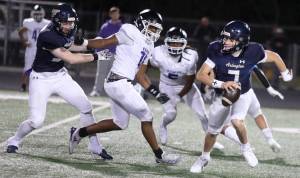 Arlington High School senior quarterback Leyton Martin scrambles during the Wesco 4A game against Kamiak High School at John C. Larson Stadium, in Arlington, Washington, on Sept. 27, 2024. Arlington won 52-7. (Taras McCurdie / The Herald)