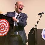 Edmonds Mayor Mike Rosen is reflected in a countertop as he pulls out a bullseye shirt at the start of his 2025 budget presentation at the Edmonds Waterfront Center on Tuesday, Oct. 1, 2024 in Edmonds, Washington. (Olivia Vanni / The Herald)