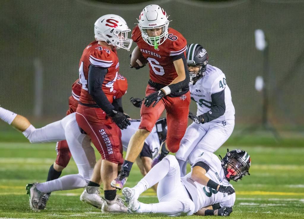 Snohomishs Parker Jackson leaps over another player while running the ball during the game against Mount Vernon on Friday, Oct. 4, 2024 in Snohomish, Washington. (Olivia Vanni / The Herald)