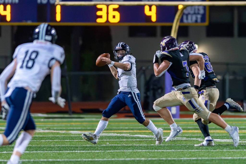 Glacier Peaks Lucas Entler looks to pass while under pressure from Lake Stevens defensive players during a game in Lake Stevens, Wash., on Friday, Oct. 4, 2024. (John Gardner / Pro Action Image)