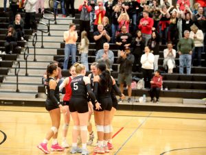 Members of the Archbishop Murphy volleyball team celebrate after scoring a point in a Wesco 3A/2A South matchup against Edmonds-Woodway in Everett, Wash., on Oct. 9, 2024. The unranked Wildcats won 3-1 and handed the No. 10 Warriors their first loss of the season. (Taras McCurdie / The Herald)