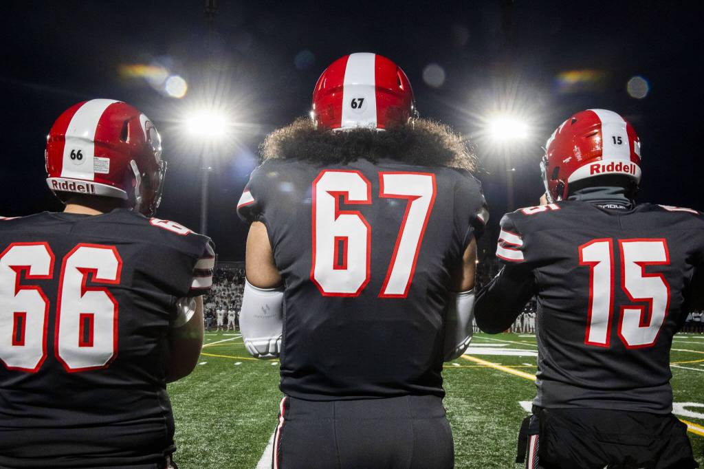 Stanwood players stand on the sideline before the start of the Stilly Cup game against Arlington on Friday, Oct. 11, 2024 in Stanwood, Washington. (Olivia Vanni / The Herald)
