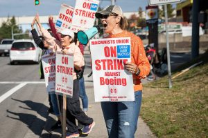 Jan James, a material processing specialist team lead who has been with Boeing for 22 years, uses a small megaphone to encourage drivers to honk in support of workers picketing along Airport Road on Tuesday, Oct. 1, 2024 in Everett, Washington. (Olivia Vanni / The Herald)