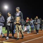 Kordelle Hammond holds a photograph of his cousin Shaylee Chuckulnaskit while her mother Lavina Phillips walks beside him during a memorial walk on the 10-year anniversary of the shooting at Marysville Pilchuck High School on Thursday, Oct. 24, 2024 in Marysville, Washington. (Olivia Vanni / The Herald)