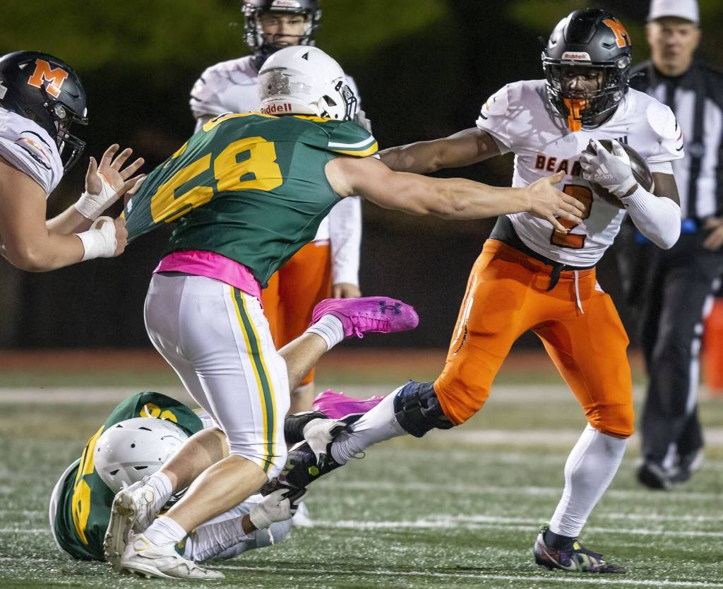 Monroes Carl Watson III sticks his arm out to block a tackle during the game against Shorecrest on Friday, Oct. 18, 2024 in Shoreline, Washington. (Olivia Vanni / The Herald)