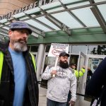 Matt Farnum, center, a machine repair mechanic at Boeing for 14 years, stands outside of Angel of the Winds Arena holding a “vote no” sign as people file inside to vote on the proposed contract on Wednesday, Oct. 23, 2024 in Everett, Washington. “I’ll be voting no until the collective approves the contract. It’s not just about me it’s about everyone else,” said Farnum. (Olivia Vanni / The Herald)