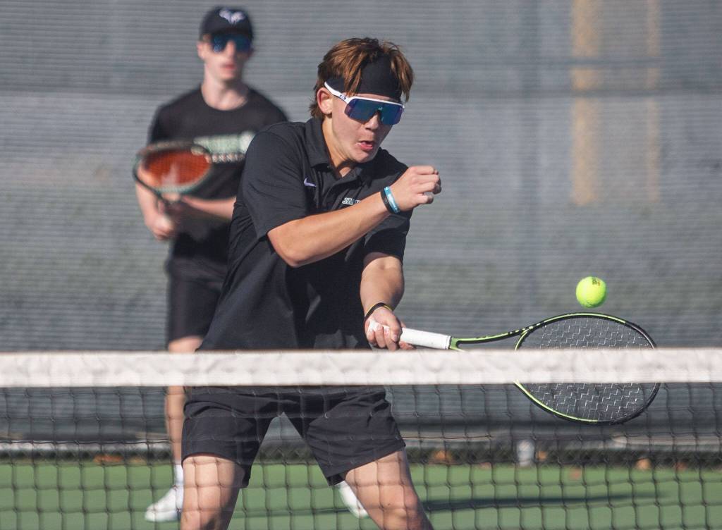 Ashton Bergman hits the ball during the district championship doubles match on Thursday, Oct. 24, 2024 in Snohomish, Washington. (Olivia Vanni / The Herald)