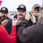 Tyler Nicholson, from Carbondale, Colorado, makes a face as he gets his mustache clipped together during a Guinness World Record Moustache Chain Attempt on Friday, Nov. 1, 2024 in Everett, Washington. (Olivia Vanni / The Herald)