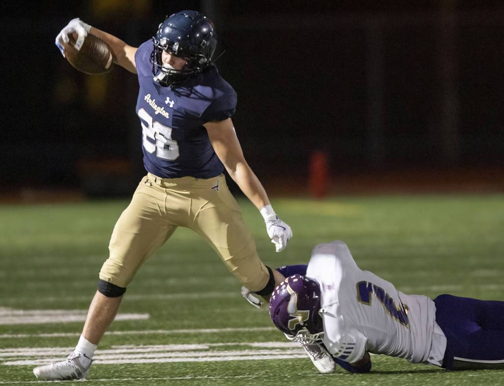 Lake Stevens Kekoa Okiyama hangs onto the leg of Arlingtons Caleb Reed as he runs with the ball during the game on Friday, Nov. 1, 2024 in Arlington, Washington. (Olivia Vanni / The Herald)