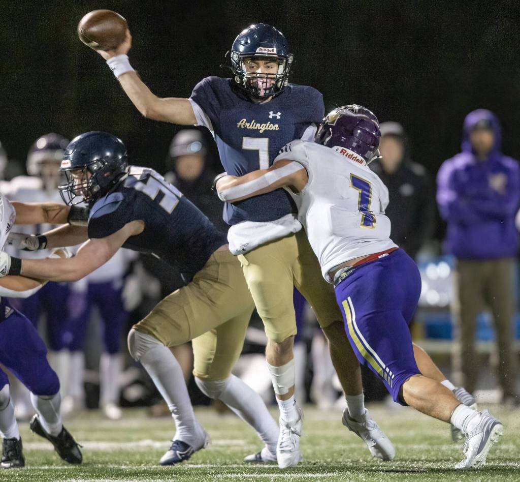 Arlingtons Leyton Martin is tackled by Lake Stevens Keagan Howard while throwing the ball during the game on Friday, Nov. 1, 2024 in Arlington, Washington. (Olivia Vanni / The Herald)