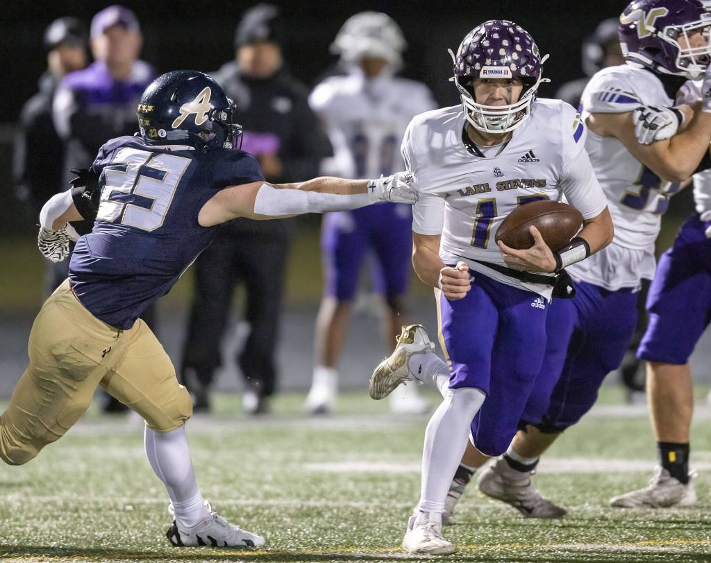 Arlingtons Jace Graham reaches out and grabs the jersey of Lake Stevens Kolton Matson as he runs with the ball during the game on Friday, Nov. 1, 2024 in Arlington, Washington. (Olivia Vanni / The Herald)