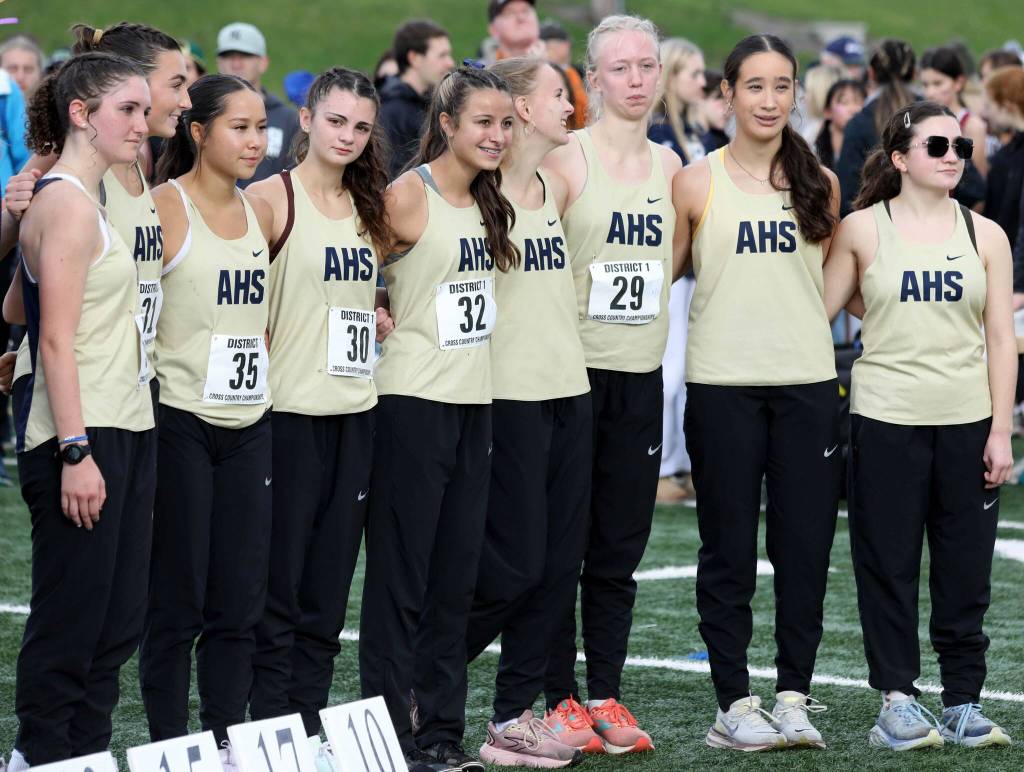 Members of the Arlington High School girls cross country team pose for a photo at the District 1/2 Cross Country Championships at Lakewood High School in Arlington, Wash., on Nov. 2, 2024. The Eagles finished fifth in 4A. (Taras McCurdie / The Herald)