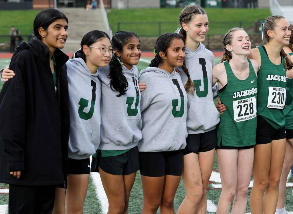 Members of the Jackson High School girls cross country team pose for a photo at the District 1/2 Cross Country Championships at Lakewood High School in Arlington, Wash., on Nov. 2, 2024. The Timberwolves finished sixth in 4A. (Taras McCurdie / The Herald)