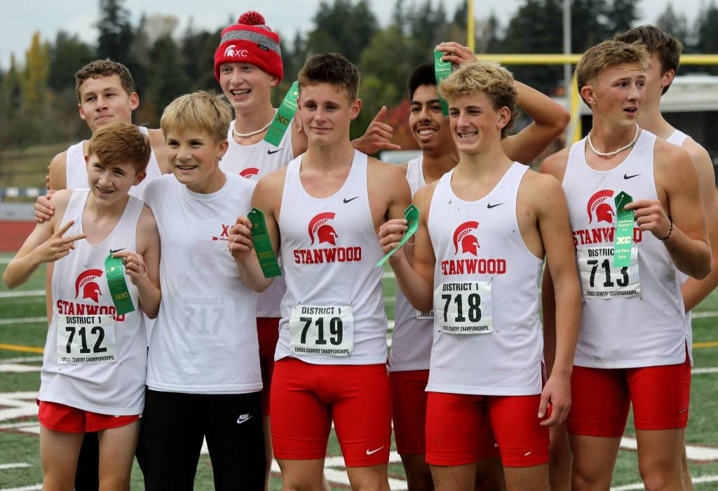 Members of the Stanwood High School boys cross country team pose for a photo at the District 1/2 Cross Country Championships at Lakewood High School in Arlington, Wash., on Nov. 2, 2024. The Spartans finished fourth in 3A. (Taras McCurdie / The Herald)
