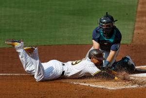 The Padres Donovan Solano is tagged out at home plate in the second inning of Wednesdays game by Mariners catcher Cal Raleigh. (K.C. Alfred / The San Diego Union-Tribune)
