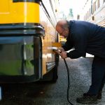 Snohomish School District’s Clayton Lovell plugs in the district’s electric bus after morning routes on Thursday, March 7, 2024, at the district bus depot in Snohomish, Washington. (Ryan Berry / The Herald)
