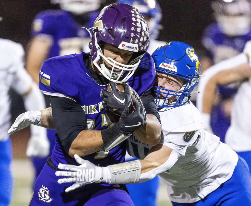 Lake Stevens Jayshon Limar grimaces while being tackled by Tahomas Ben Altick during the 4A district game on Friday, Nov. 8, 2024 in Lake Stevens, Washington. (Olivia Vanni / The Herald)