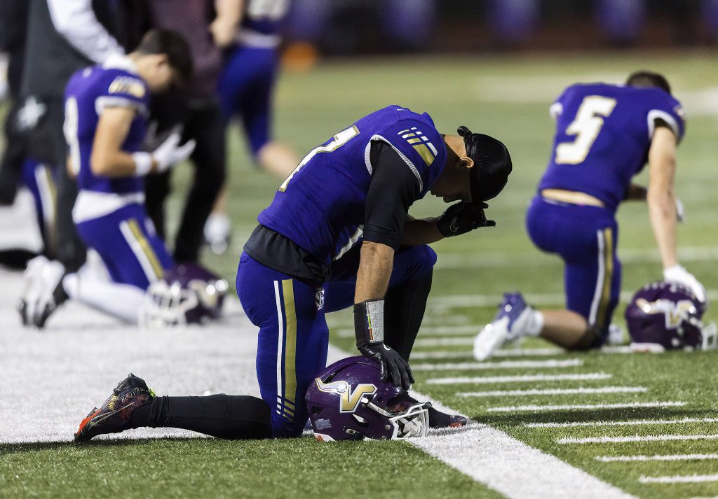Lake Stevens players take a moment to kneel before the start of the 4A district game against Tahoma on Friday, Nov. 8, 2024 in Lake Stevens, Washington. (Olivia Vanni / The Herald)