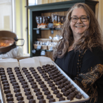 Mona Newbauer poses for a photo with caramels inside her store Sweet Monas Chocolates on March 21, 2024 in Langley. (Annie Barker / The Herald)