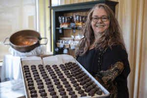 Mona Newbauer poses for a photo with caramels inside her store Sweet Monas Chocolates on March 21, 2024 in Langley. (Annie Barker / The Herald)