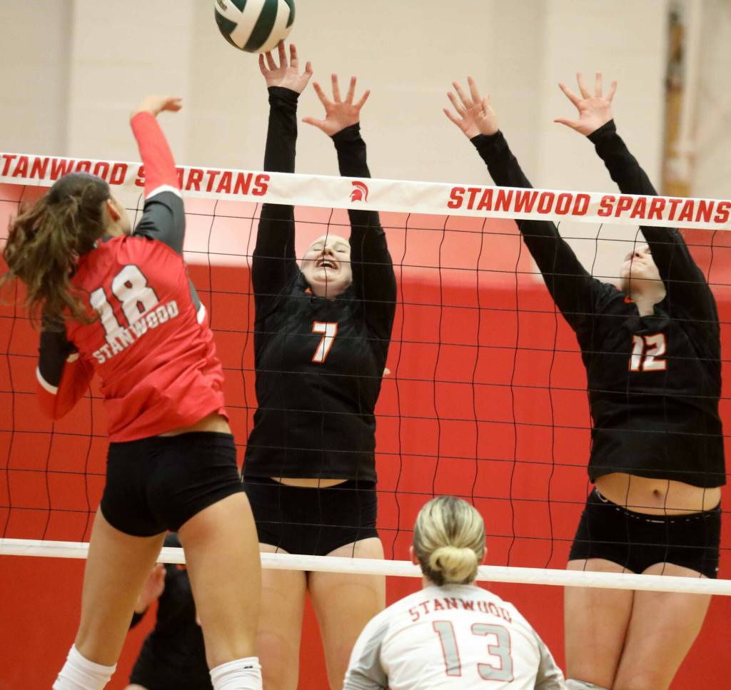 Monroe juniors Faith Fodge (No. 7) and Katelyn Cockrum (No. 12) attempt to block Stanwood sophomore outside hitter Whitney Longspaughs hit during a District 1 3A quarterfinals match in Stanwood, Wash., on Tuesday, Nov. 12, 2024. The Spartans won 3-1. (Taras McCurdie / The Herald)
