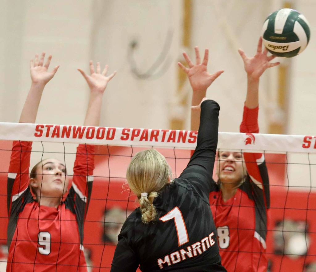 Stanwood junior middle blocker Presley Harris (No. 9) and junior setter Olivia Wildenberg (No. 8) attempt to block Monroe junior Faith Fodges hit during a District 1 3A quarterfinals match in Stanwood, Wash., on Tuesday, Nov. 12, 2024. The Spartans won 3-1. (Taras McCurdie / The Herald)