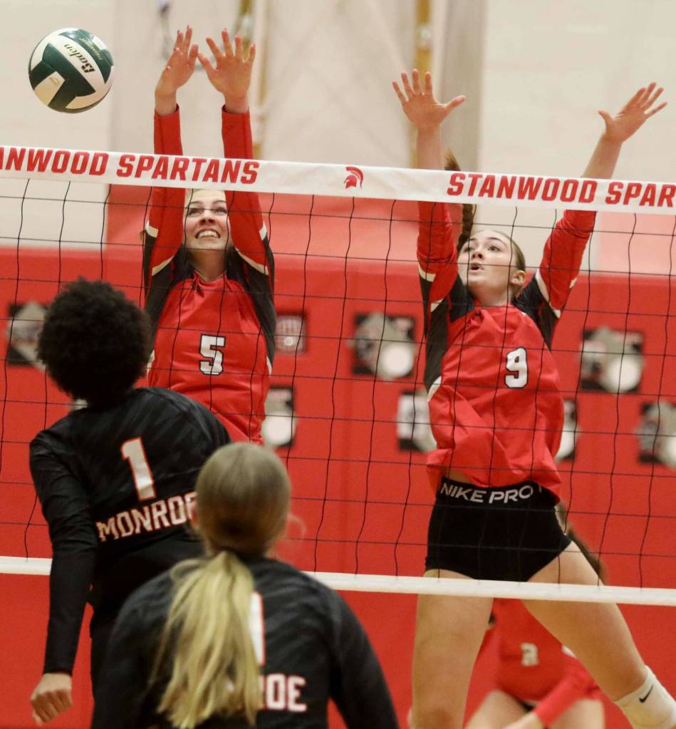 Stanwood junior setter Addison Bowie (No. 5) and junior middle blocker Presley Harris (No. 9) attempt to block Monroe sophomore Shannara Peebles hit during a District 1 3A quarterfinals match in Stanwood, Wash., on Tuesday, Nov. 12, 2024. The Spartans won 3-1. (Taras McCurdie / The Herald)
