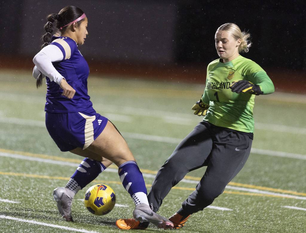 Lake Stevens Keira Isabelle Tupua and Richlands Makenzie Christian both run at the ball during the 4A state playoff game against Richland on Wednesday, Nov. 13, 2024 in Lake Stevens, Washington. (Olivia Vanni / The Herald)