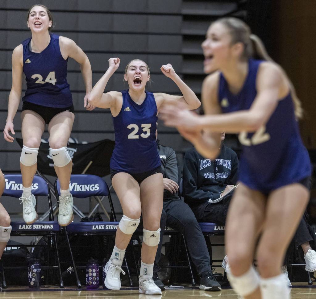 Lake Stevens Madison Sowers and Kamryn Strom celebrate a point from the bench during the 4A district semifinal game on Thursday, Nov. 14, 2024 in Lynnwood, Washington. (Olivia Vanni / The Herald)