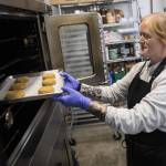 Katherine Hillman places her ginger molasses cookies in the oven to bake on Wednesday, Oct. 2, 2024 in Everett, Washington. (Olivia Vanni / The Herald)