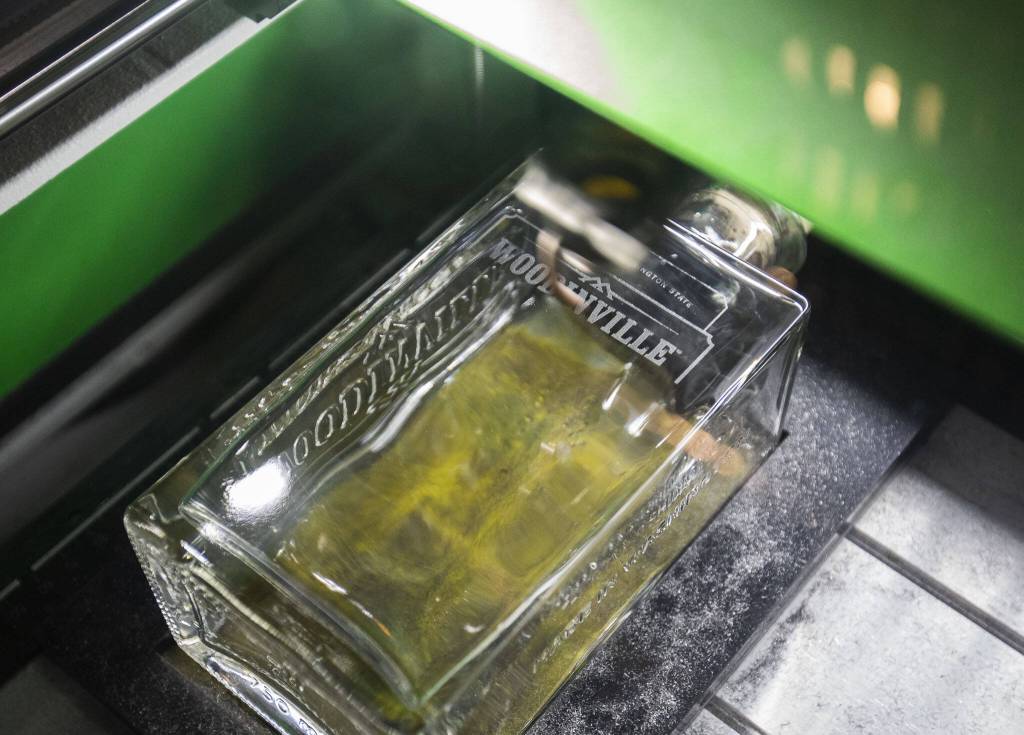 A Woodinville Whiskey bottle is customized on Monday, Oct. 7, 2024 in Woodinville, Washington. (Olivia Vanni / The Herald)
