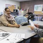 Refugee and Immigrant Services Northwest Senior Associate ESL Instructor James Wilcox, right, works on speaking and writing with Anfal Zaroug, 32, who is accompanied by her daughter Celia Hassen, 6 months, on Friday, Nov. 15, 2024 in Everett, Washington. (Olivia Vanni / The Herald)