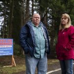 35th Avenue neighborhood residents John Ray, left, and Shelia Davis, right, next to one of many signs scattered throughout the neighborhood looking for community support on Dec. 20, 2024 in Marysville, Washington. (Olivia Vanni / The Herald)