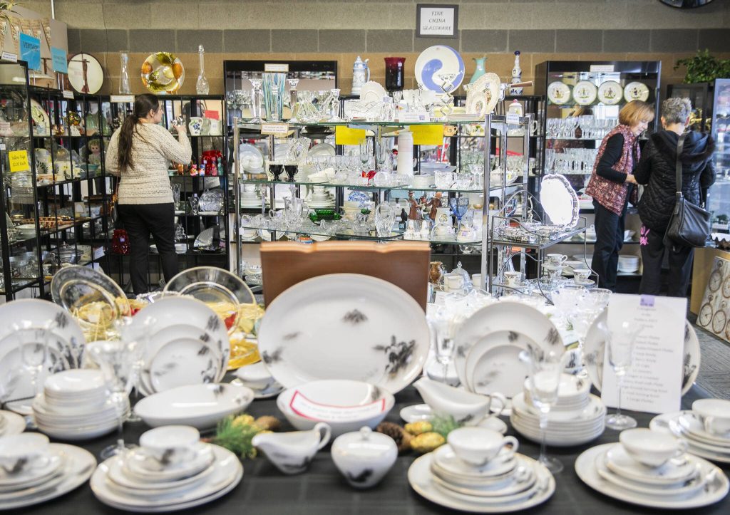 People look through dishware for sale at the Assistance League of Everetts Thrift Store on Monday, Dec. 2, 2024 in Everett, Washington. (Olivia Vanni / The Herald)