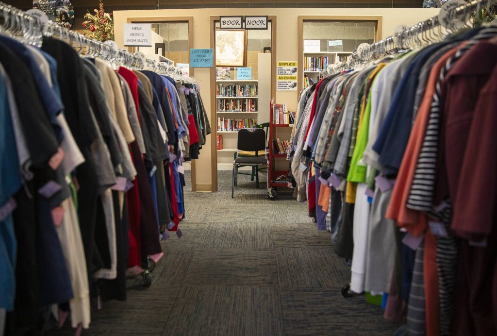 Rows of shirts lead the way to the Book Nook at the Assistance League of Everetts Thrift Store on Monday, Dec. 2, 2024 in Everett, Washington. (Olivia Vanni / The Herald)