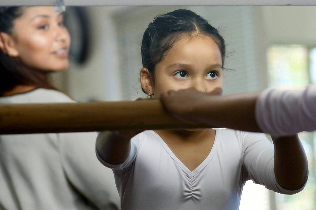 Daisy Ramos works out on the bar with Bianca Hernandez, instructor, looking on during dance class at Maris Place Monday afternoon in Everett on July 13, 2016. (Kevin Clark / The Herald)