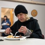 Lonnie Caravello eats dinner on Monday, Dec. 2, 2024, at the Marysville Cold Weather Shelter in Marysville, Washington. (Will Geschke / The Herald)