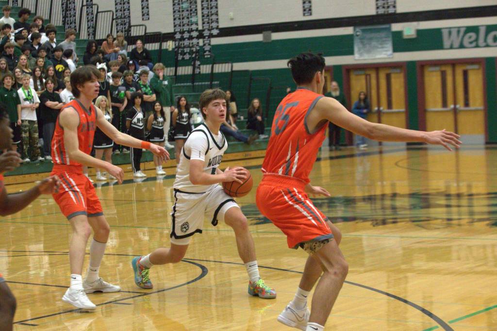 Jacksons Joey Gosline (5) looks for a pass against Monroes defense in a non-league game at Jackson High School on Dec. 3, 2024. (Aaron Coe / The Herald)